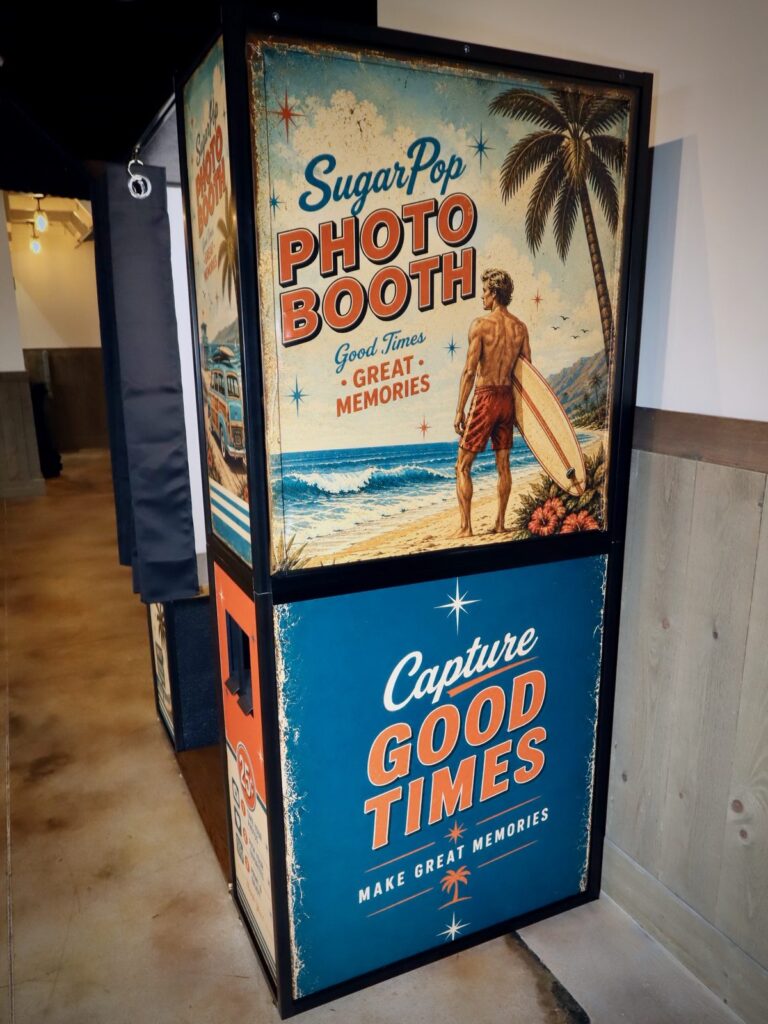 Booth panel reading Capture Good Times with a surfer on the beach