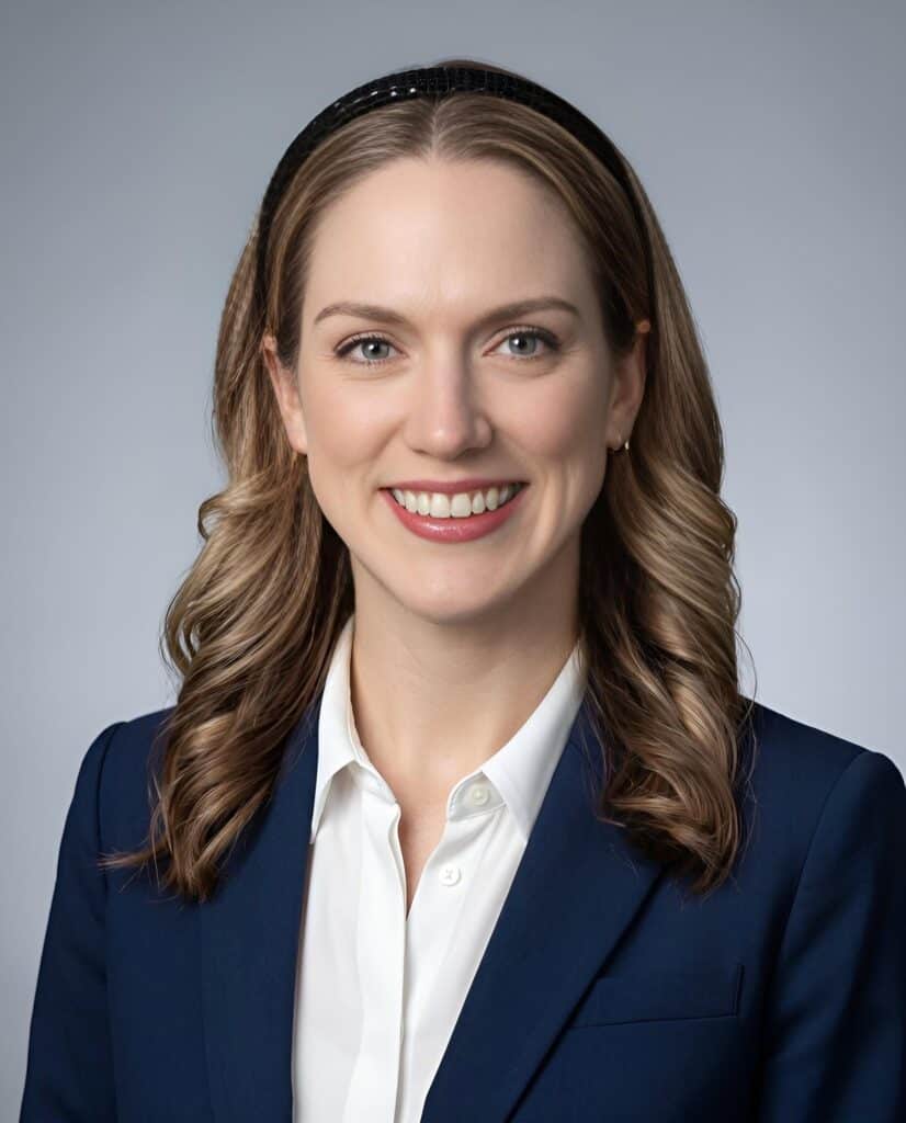 Classic AI headshot of a woman in a navy blazer on a clean neutral grey background