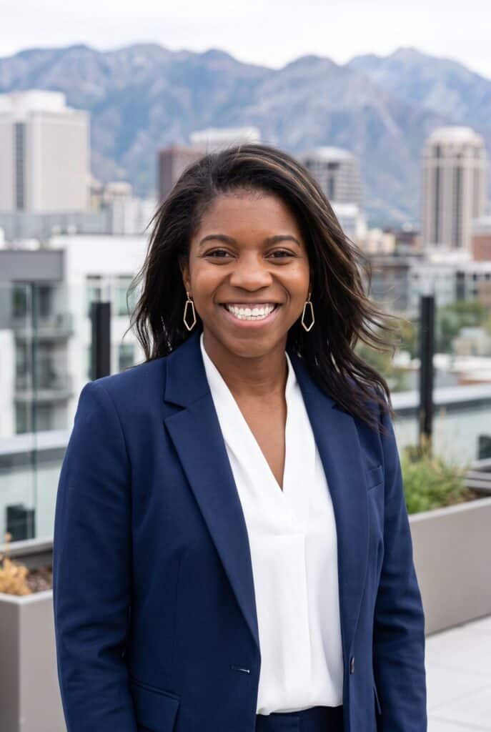 AI headshot of a woman in a navy blazer against the Salt Lake City skyline and Wasatch Range