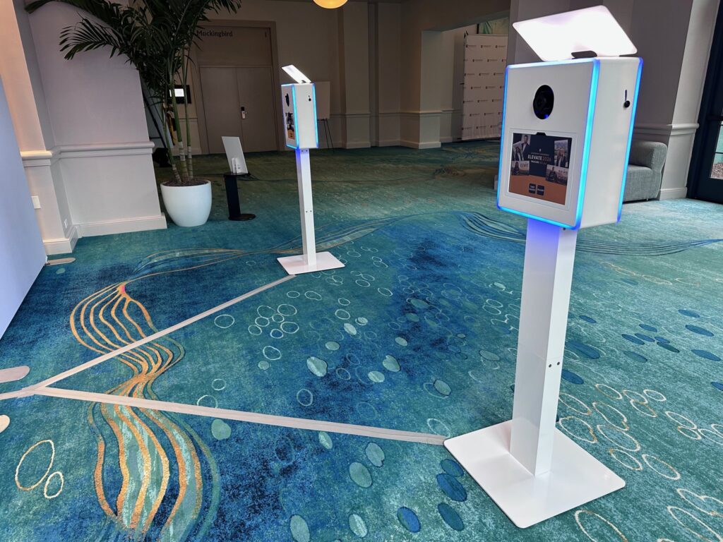 Two AI photo booth kiosks ready for scheduled attendee groups